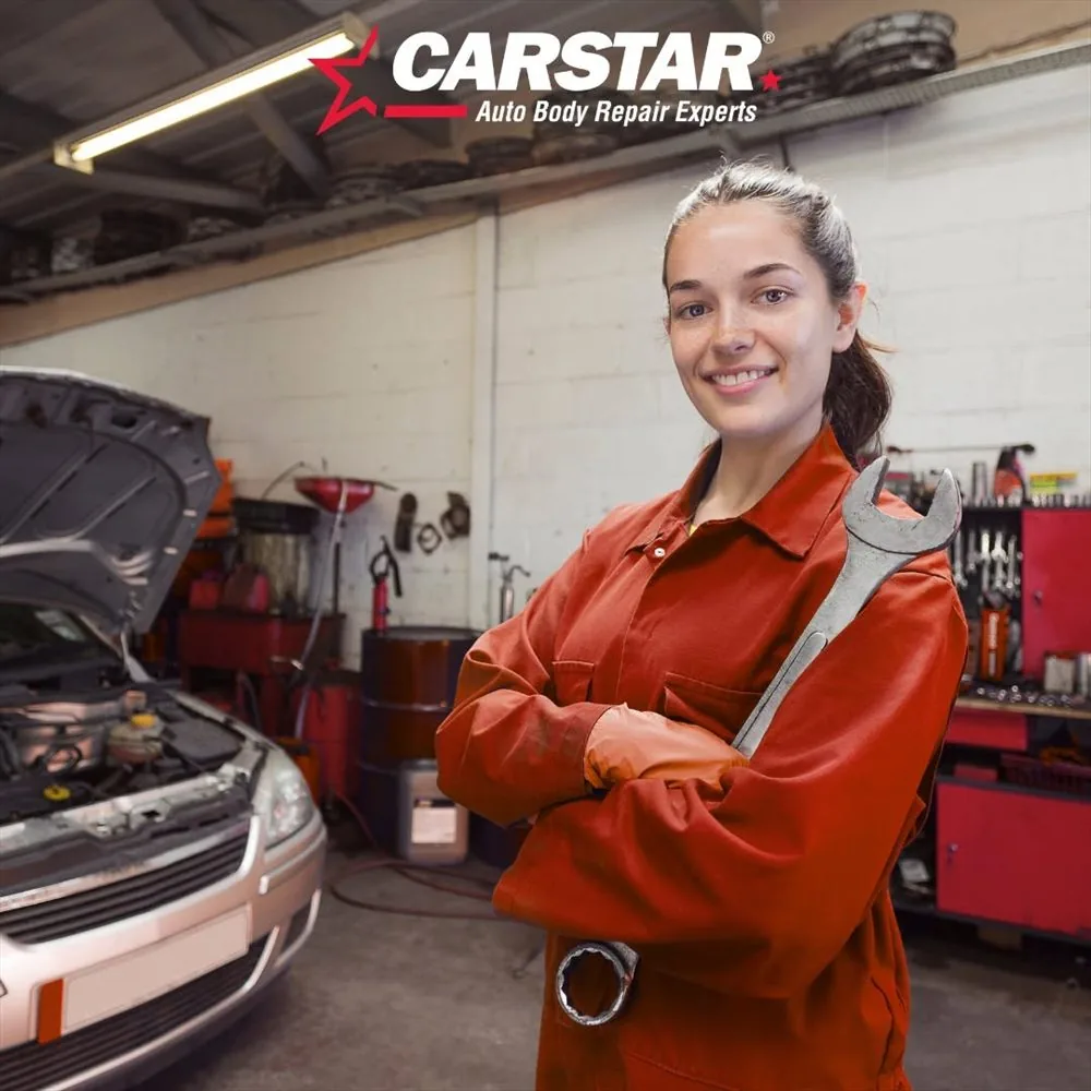A technician working on a vehicle repair with a tool